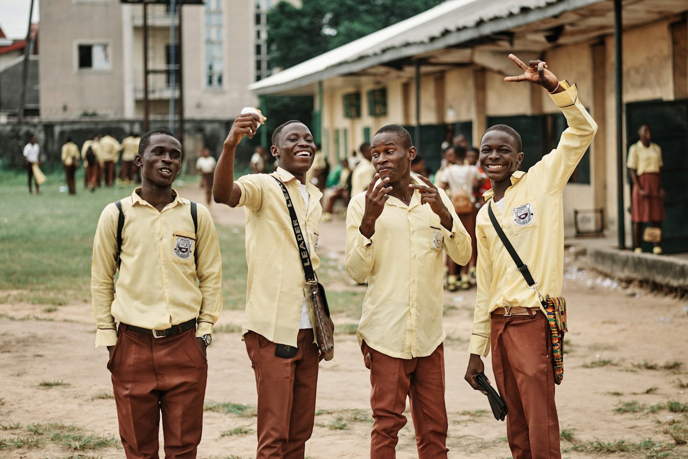 Four learners in school uniform laughing together in a school yard